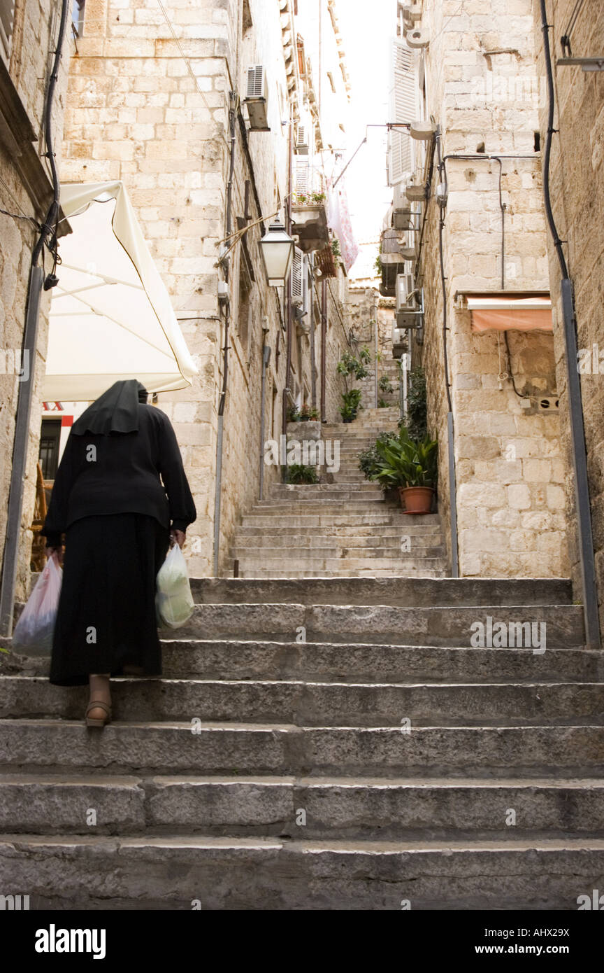 A nun ascends a set of stairs in Dubrovnik Old Town, Croatia. Stock Photo