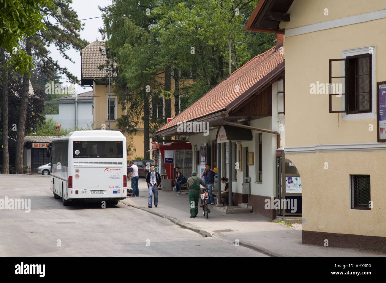 Bled Bus station in summer with single decker bus parked and people waiting  on seats outside Stock Photo - Alamy