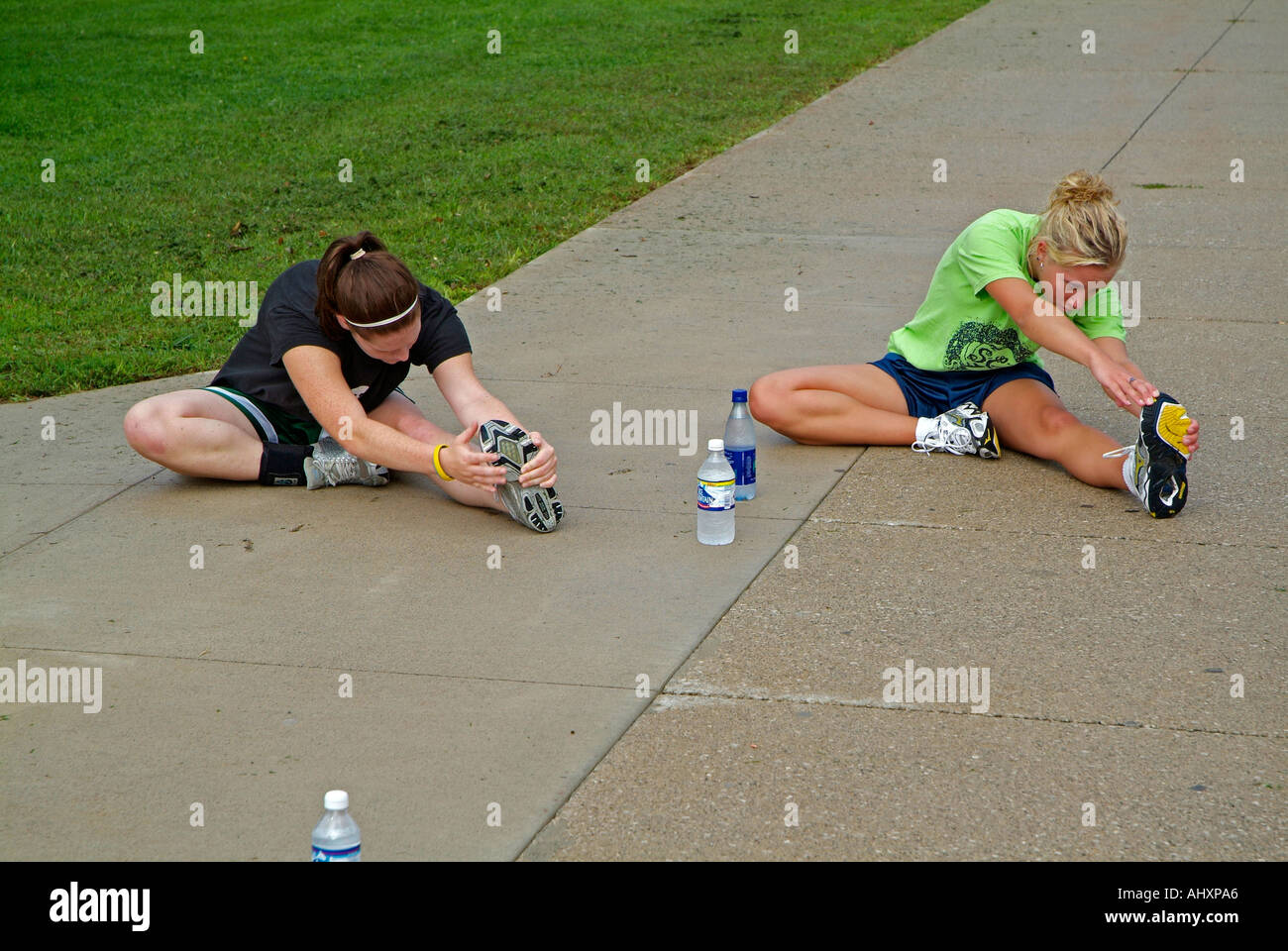High school girls cross country running team stretches their muscles
