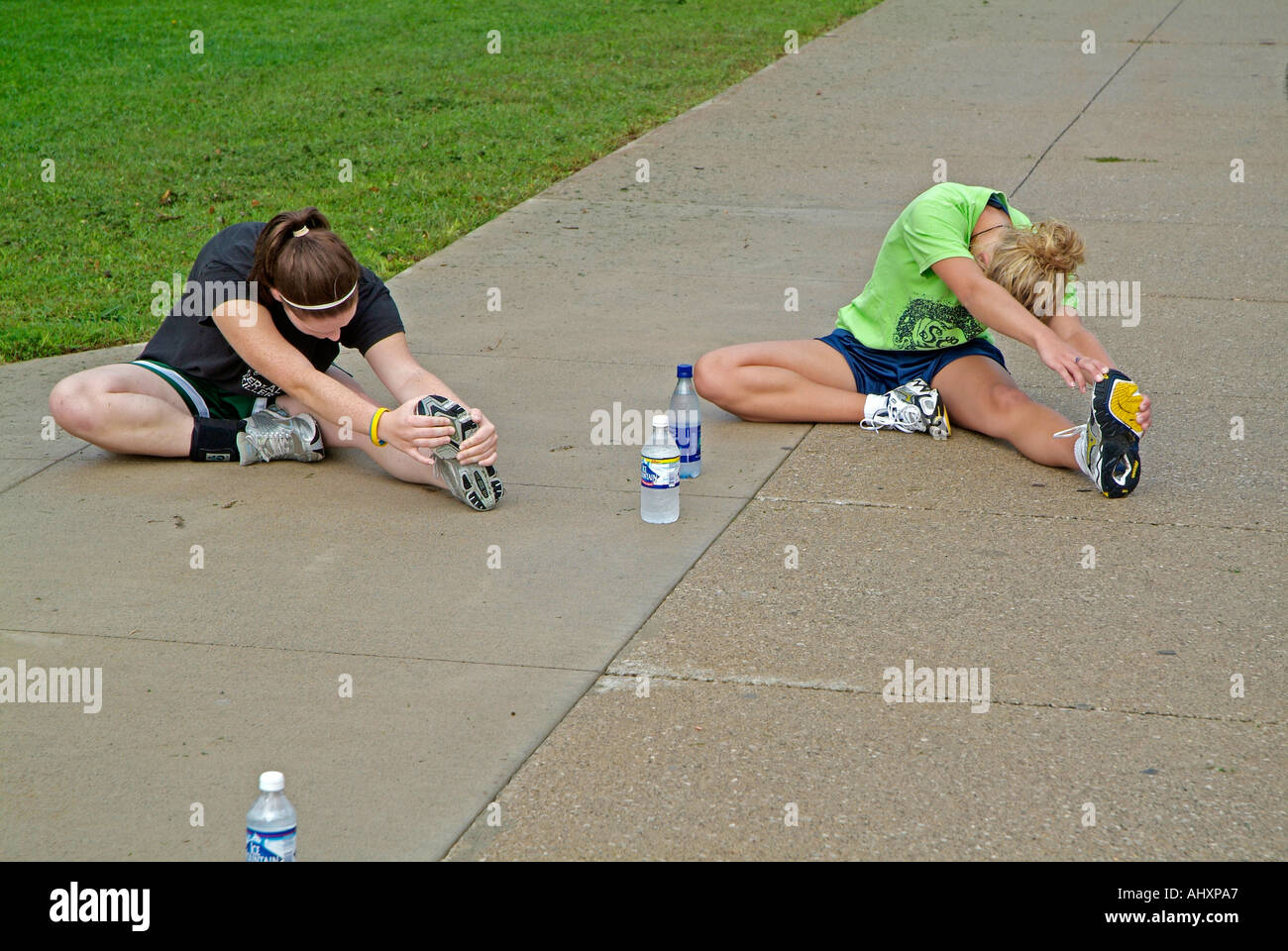 High school girls cross country running team stretches their muscles