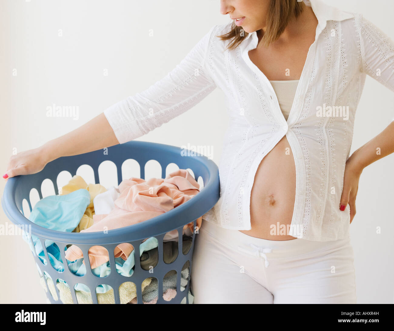 Pregnant woman holding laundry basket Stock Photo Alamy