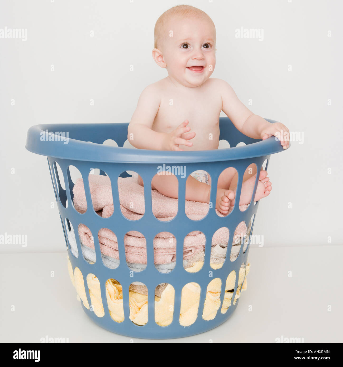 Baby sitting in laundry basket Stock Photo Alamy
