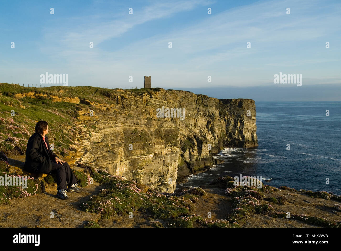 dh Marwick Head BIRSAY ORKNEY Seacliff Woman tourist RSPB Bird Nature reserve Kitchener Memorial on cliff top looking out sea one teen girl uk alone Stock Photo