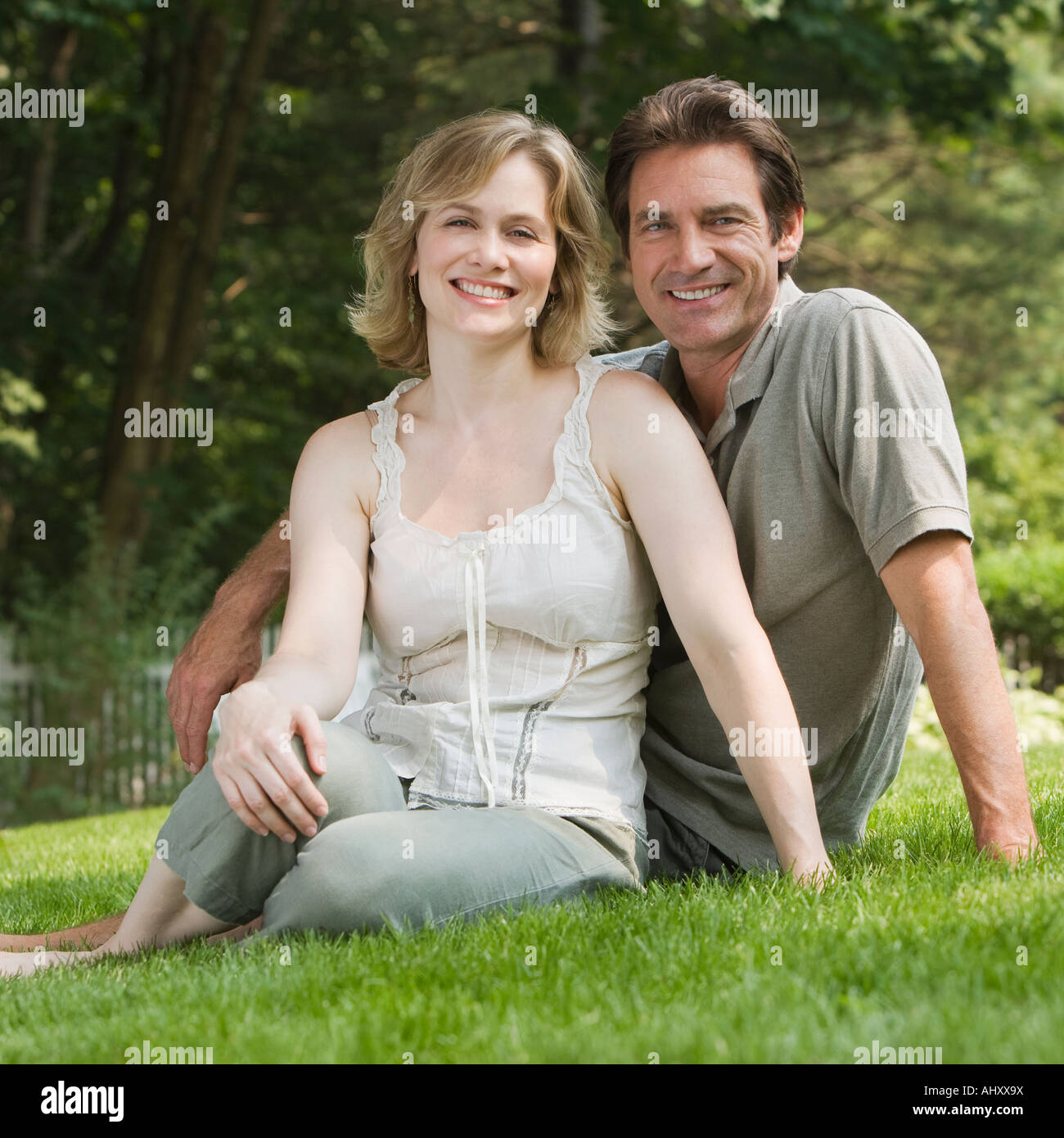 Couple sitting in grass Stock Photo - Alamy