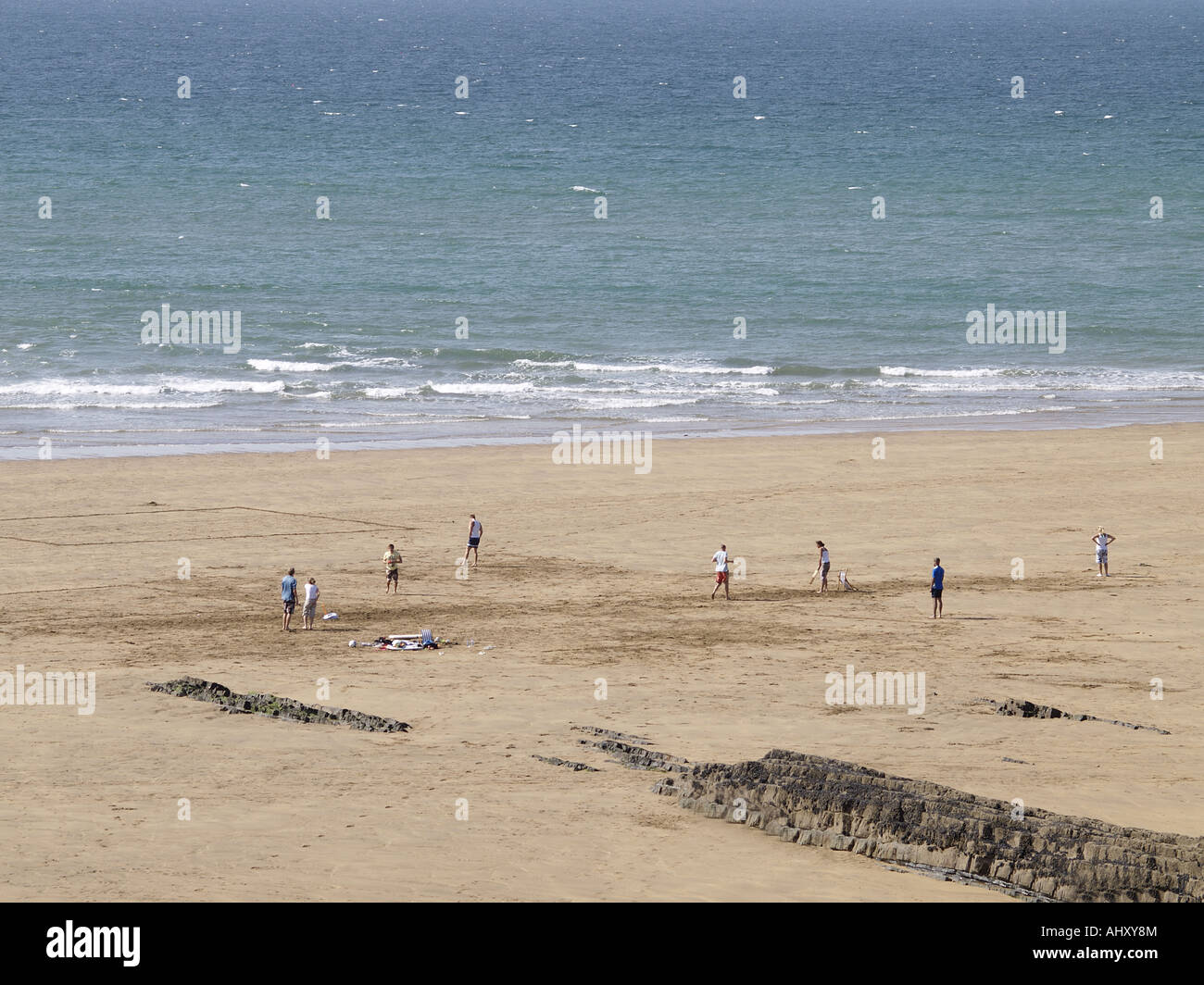 Group of holiday makers, playing cricket on a sandy beach Stock Photo