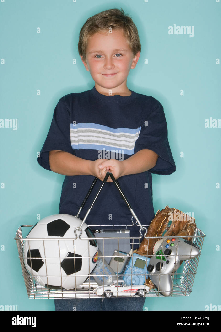 Boy holding shopping basket with toys Stock Photo Alamy