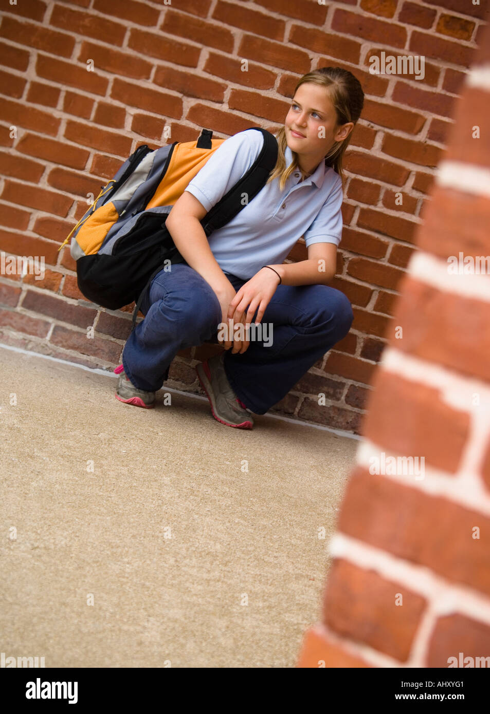 Girl in school uniform holding a backpack Stock Photo