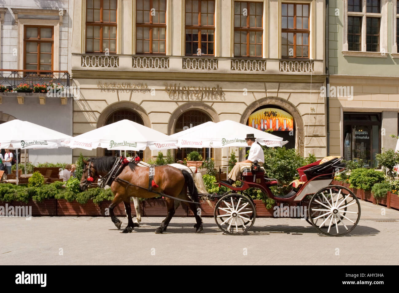 Toursi horse cab passing famous Wierzynek restaurant on main market Square in Cracow Poland Stock Photo