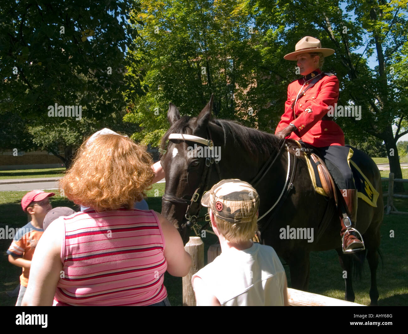 A family talking to a Mountie at the RCMP (Royal Canadian Mounted Police) Musical Ride visitor centre in Ottawa, Ontario Canada Stock Photo