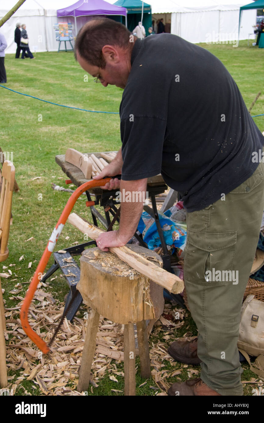 Bodger Or Woodworker Cutting A Chair Leg With A Saw Stock