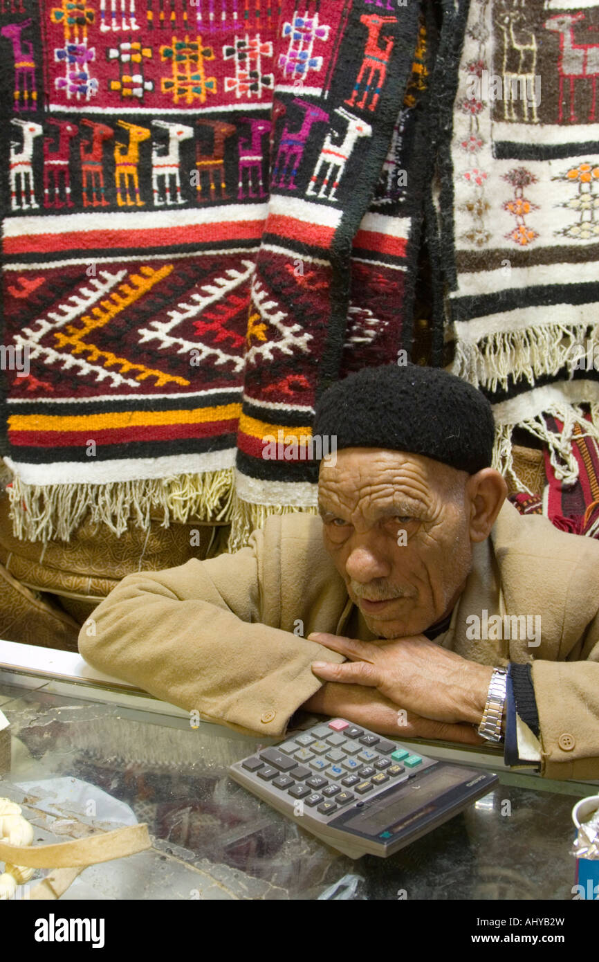 Tripoli, Libya. Rug and Souvenir Vendor in the Medina (Old City). He wears a black Tunisian chechia, a cap popular in Libya. Stock Photo