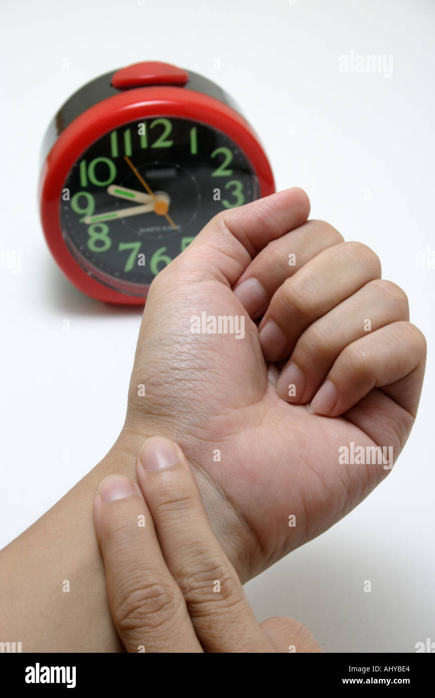 fingers taking pulse to measure heartbeat rate with clock Healthcare