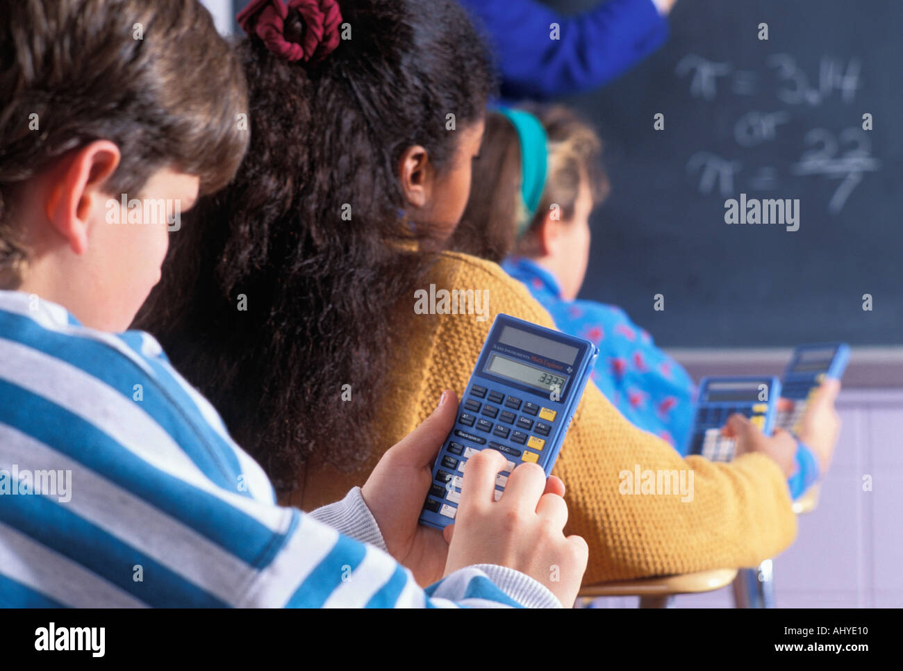 Caucasian and Asian American middle school students at desks using