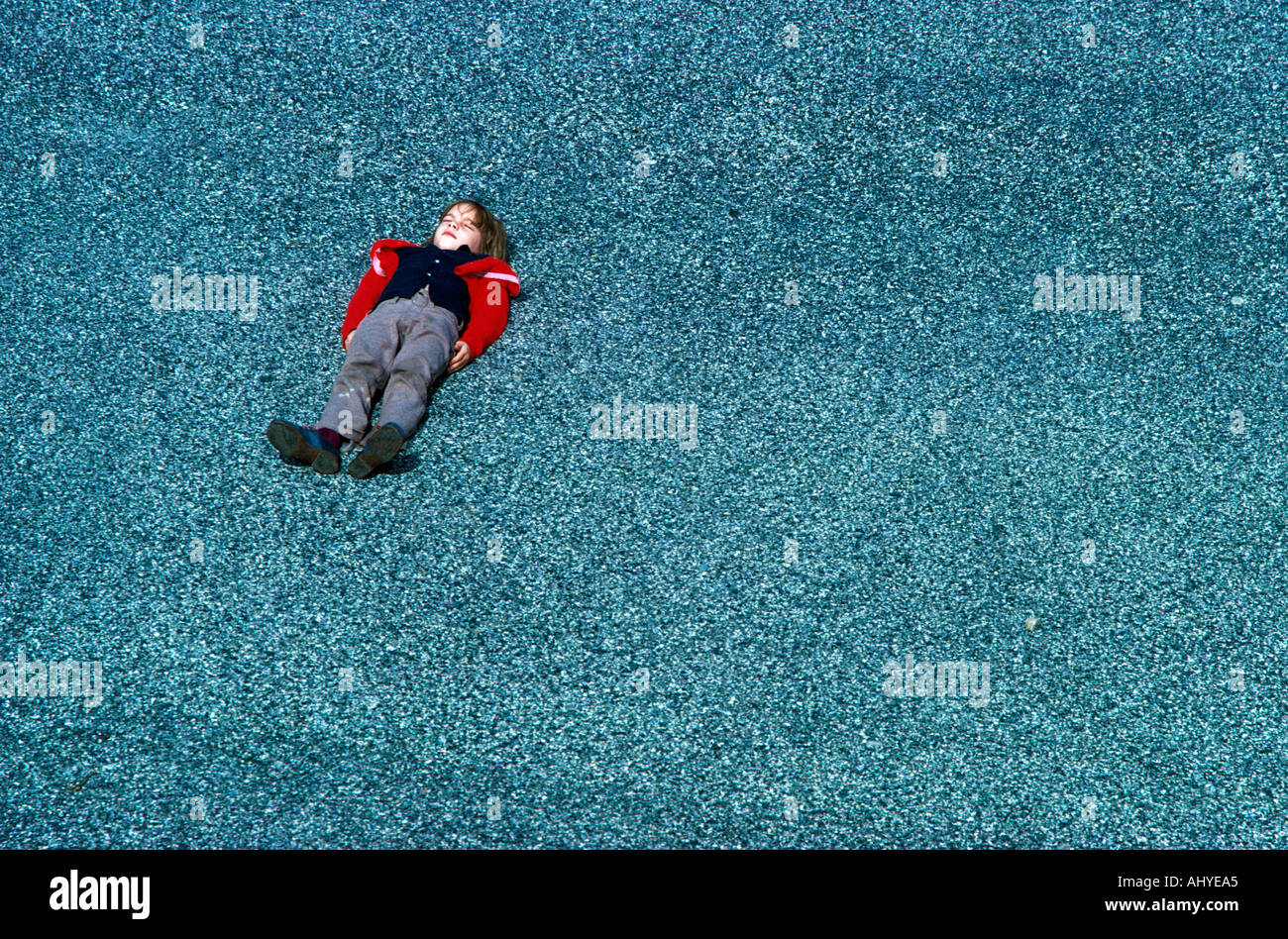 Caucasian boy lying in the street Stock Photo