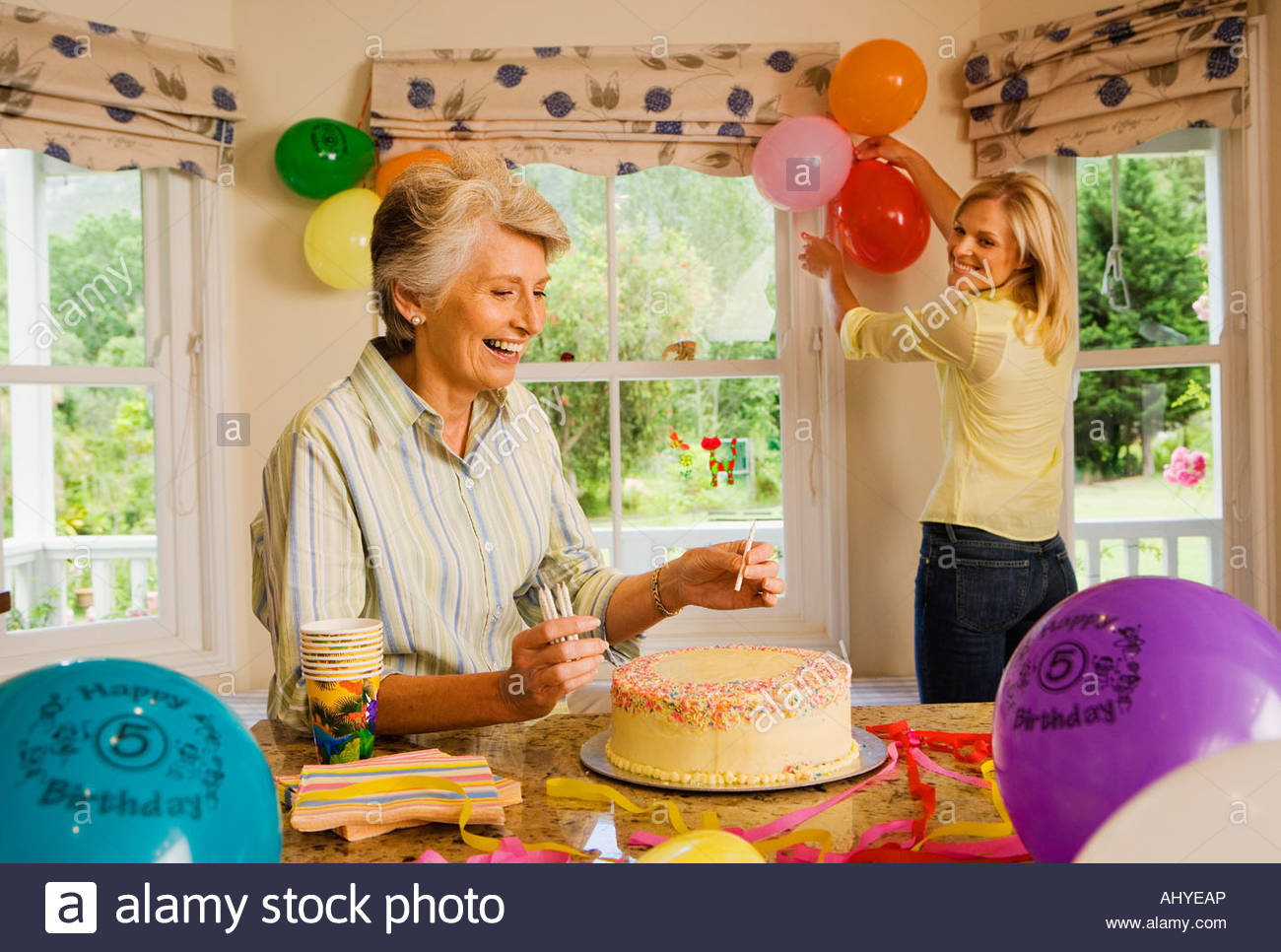 Senior woman and adult daughter preparing birthday  party  