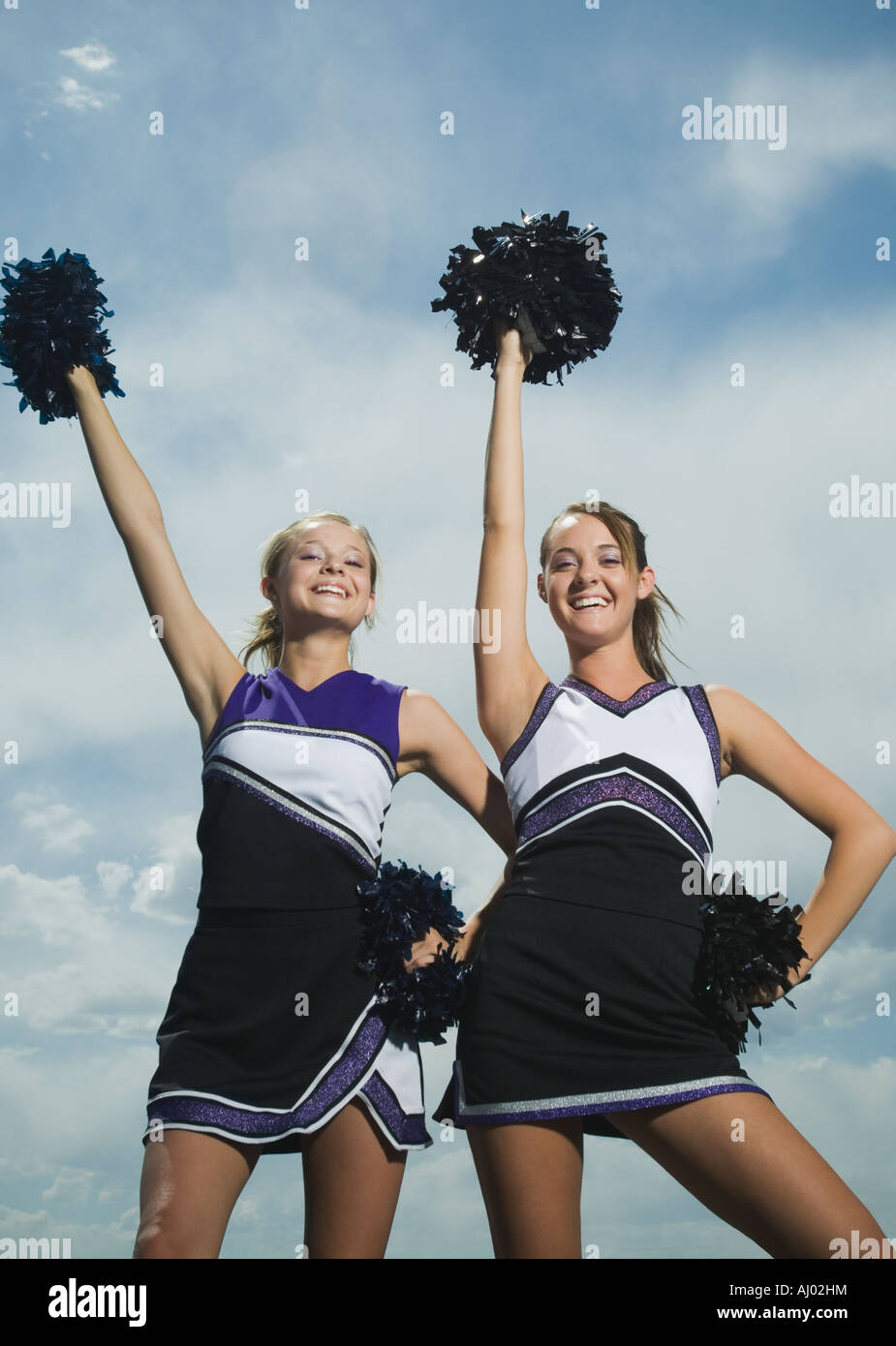 Two cheerleaders holding pom poms Stock Photo