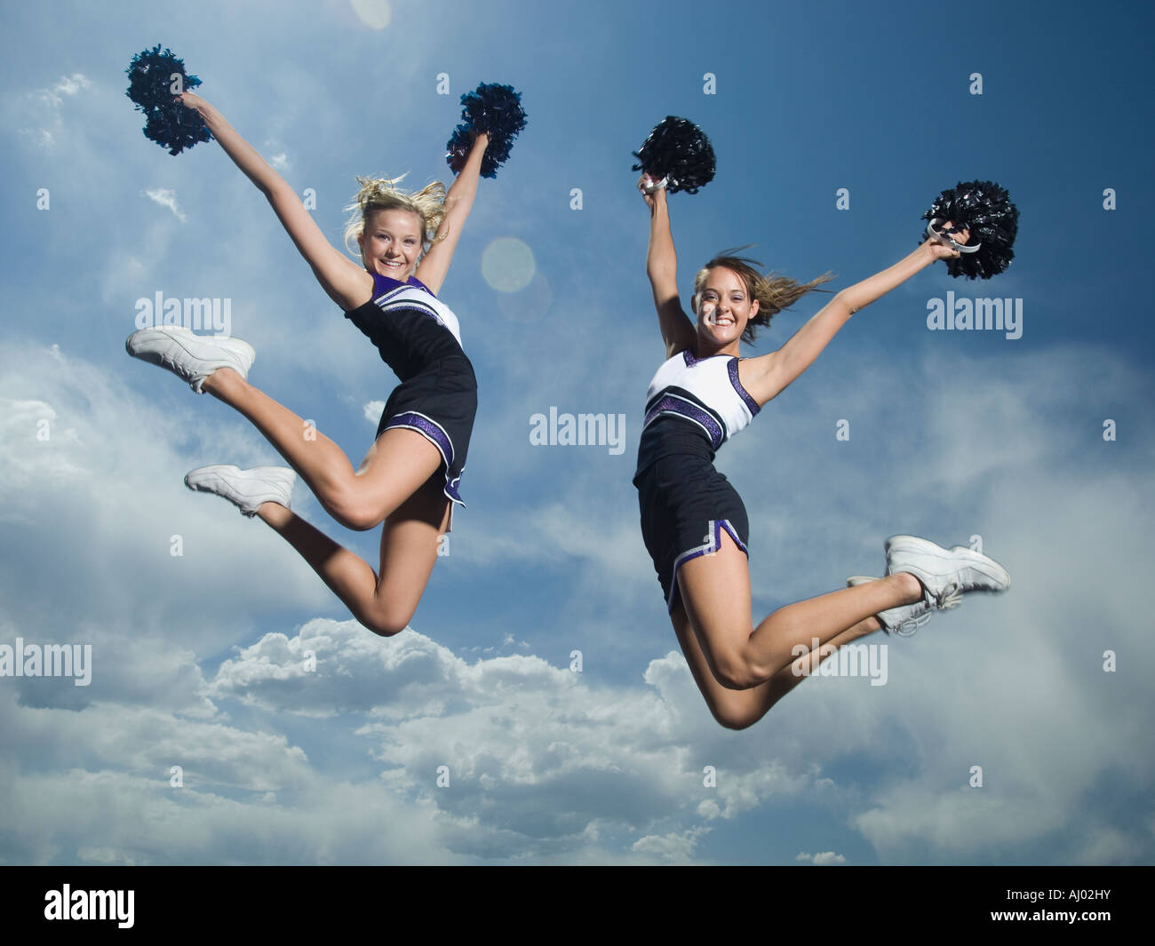 Cheerleaders with pom poms jumping Stock Photo