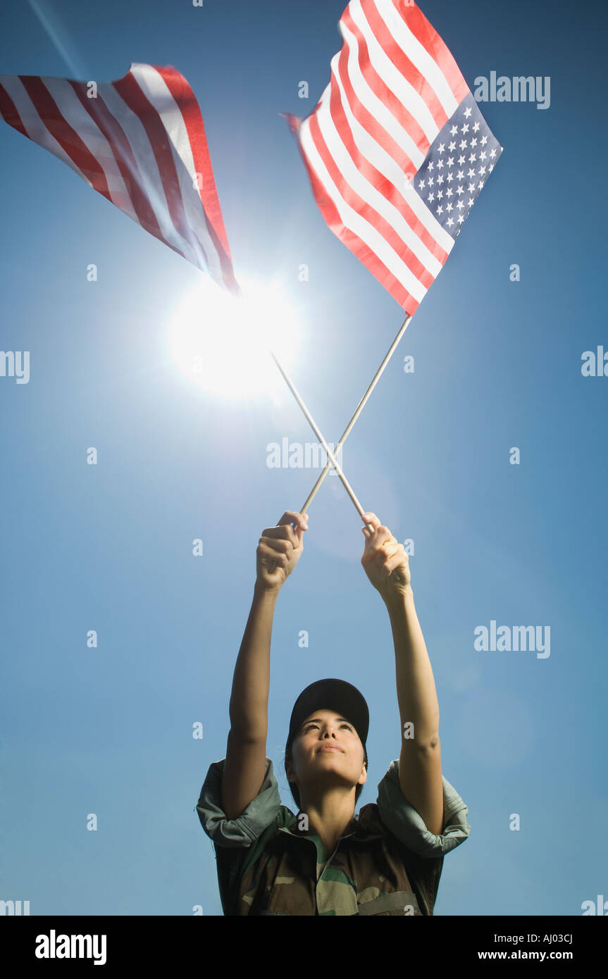 Female army soldier holding American flags Stock Photo