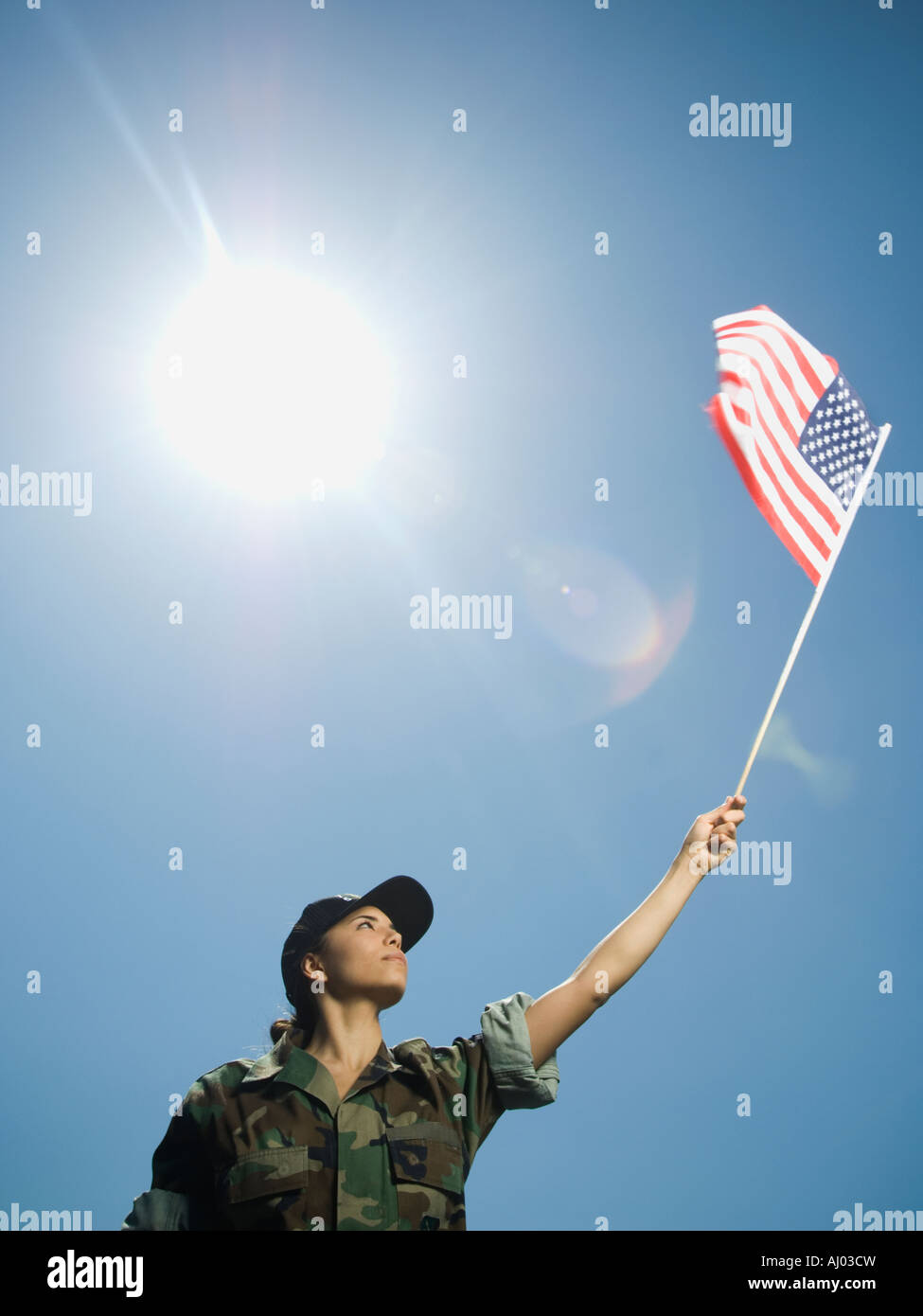 Female army soldier holding American flag Stock Photo