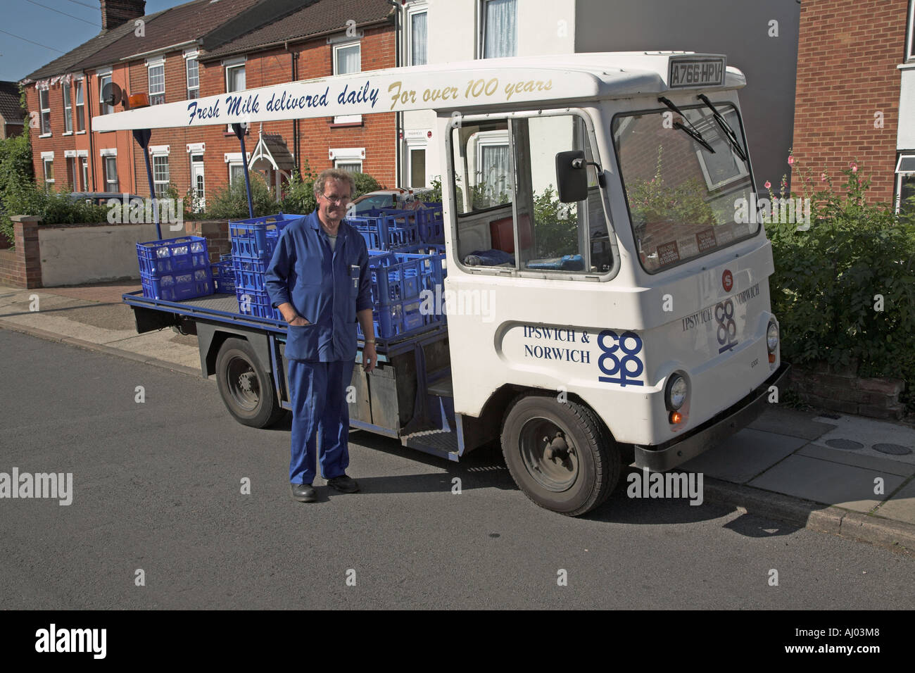 Milkman and electric powered vehicle delivering milk from house to house  Ipswich Suffolk England Stock Photo - Alamy