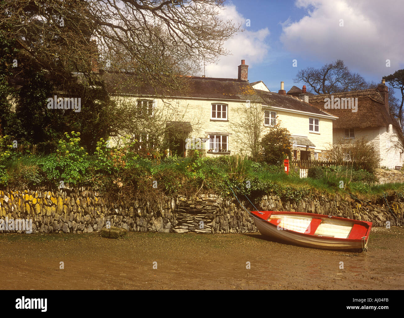 Cottages and rowing boat at low tide on the Tresillian river in the village of St Clement near Truro in Cornwall, UK Stock Photo