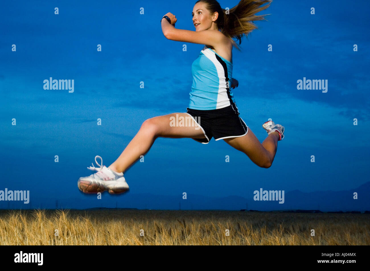 Woman in athletic gear jumping Stock Photo Alamy