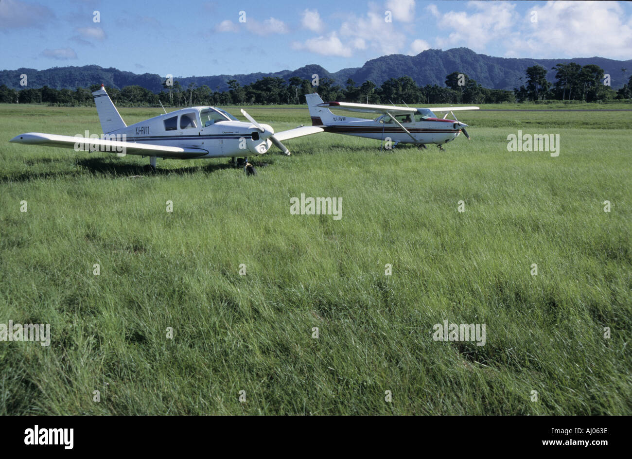 Two planes sitting side by side in the field of the Port Vila Airport, Efate Island, Vanuatu. Stock Photo