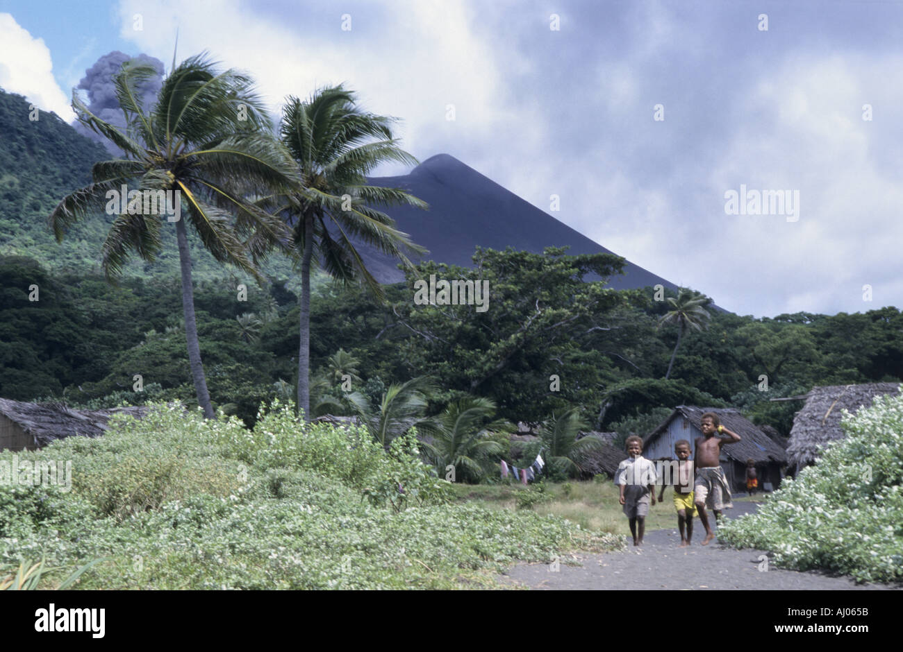 Melanesian boys walking by Yasur volcano, Sulphur Bay Village, Tanna Island, Vanuatu Stock Photo