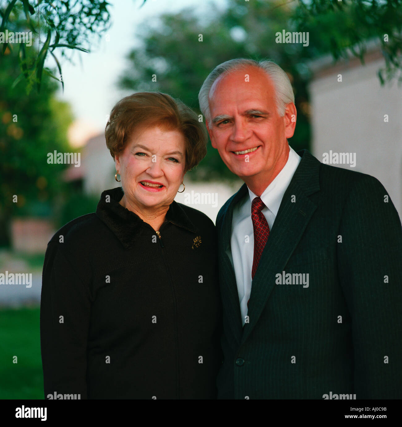 Portrait of a smiling senior couple standing together outdoors in dress clothes Stock Photo