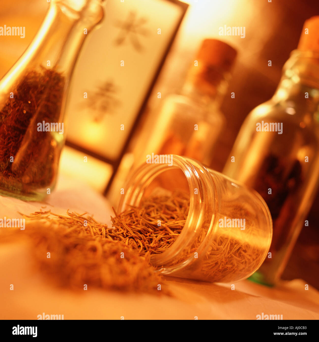 Close up of dried herbs spilling out of a glass jar at a Chinese apothecary Other containers of herbs stand in the background Stock Photo