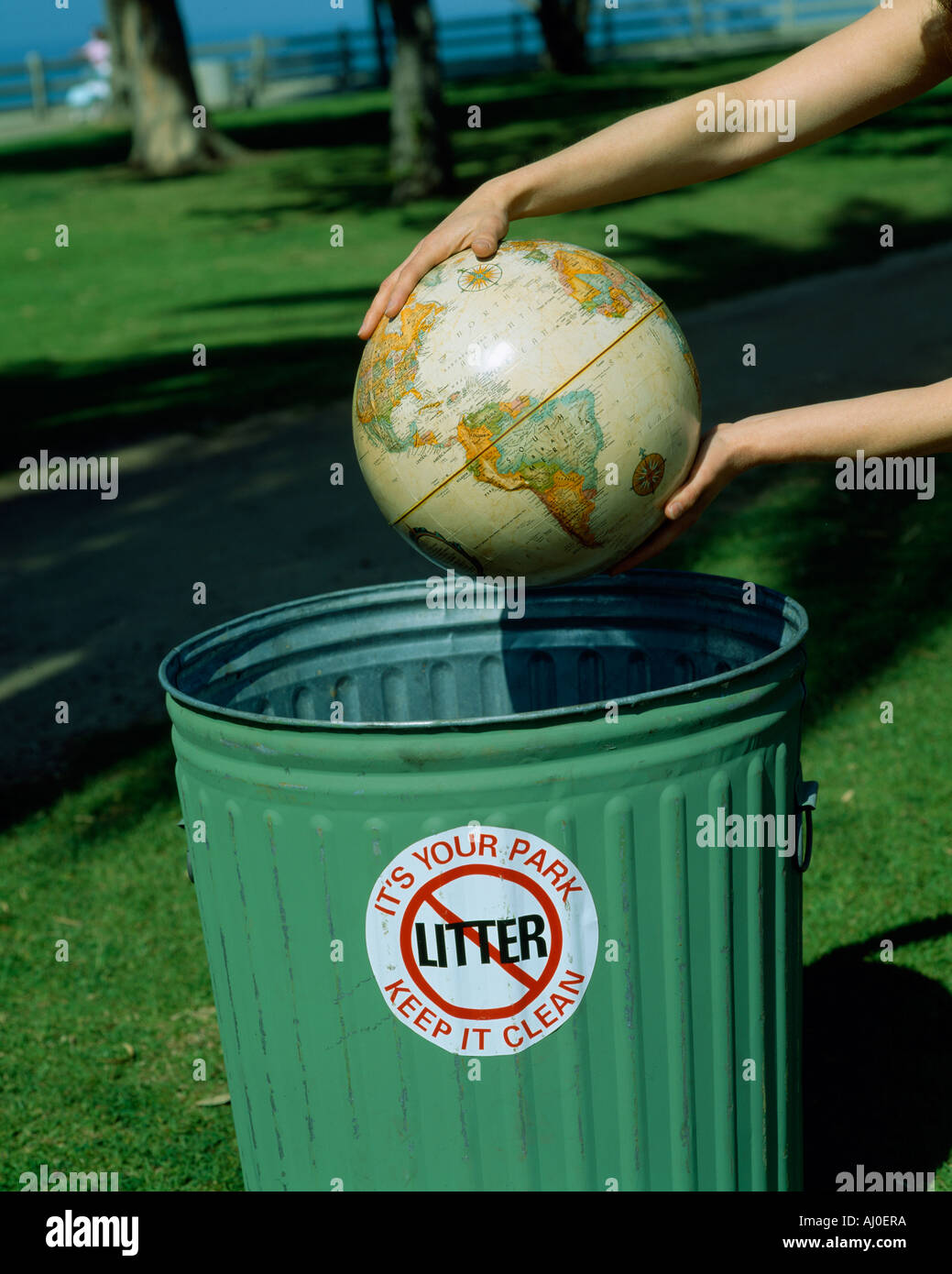 Globe in hands over waste basket environmental care Stock Photo