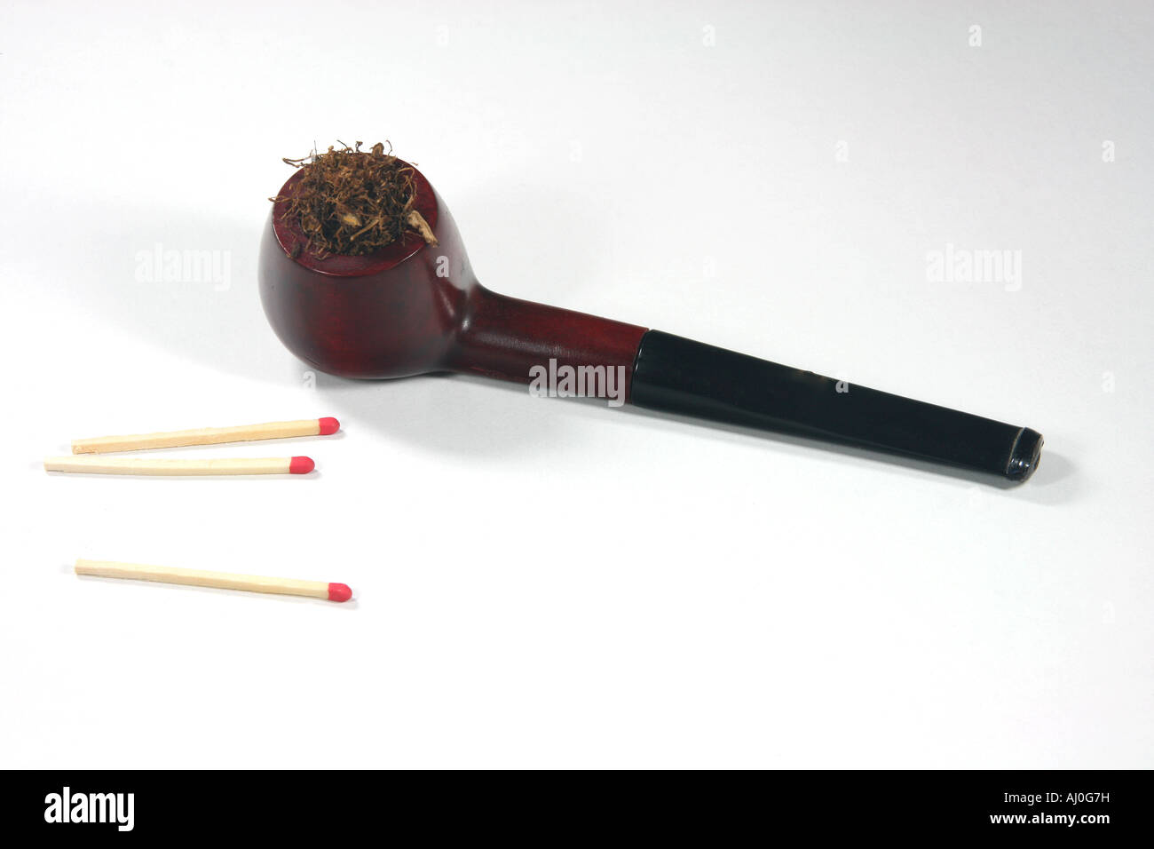 old wooden tobacco pipe with matches in white background Stock Photo