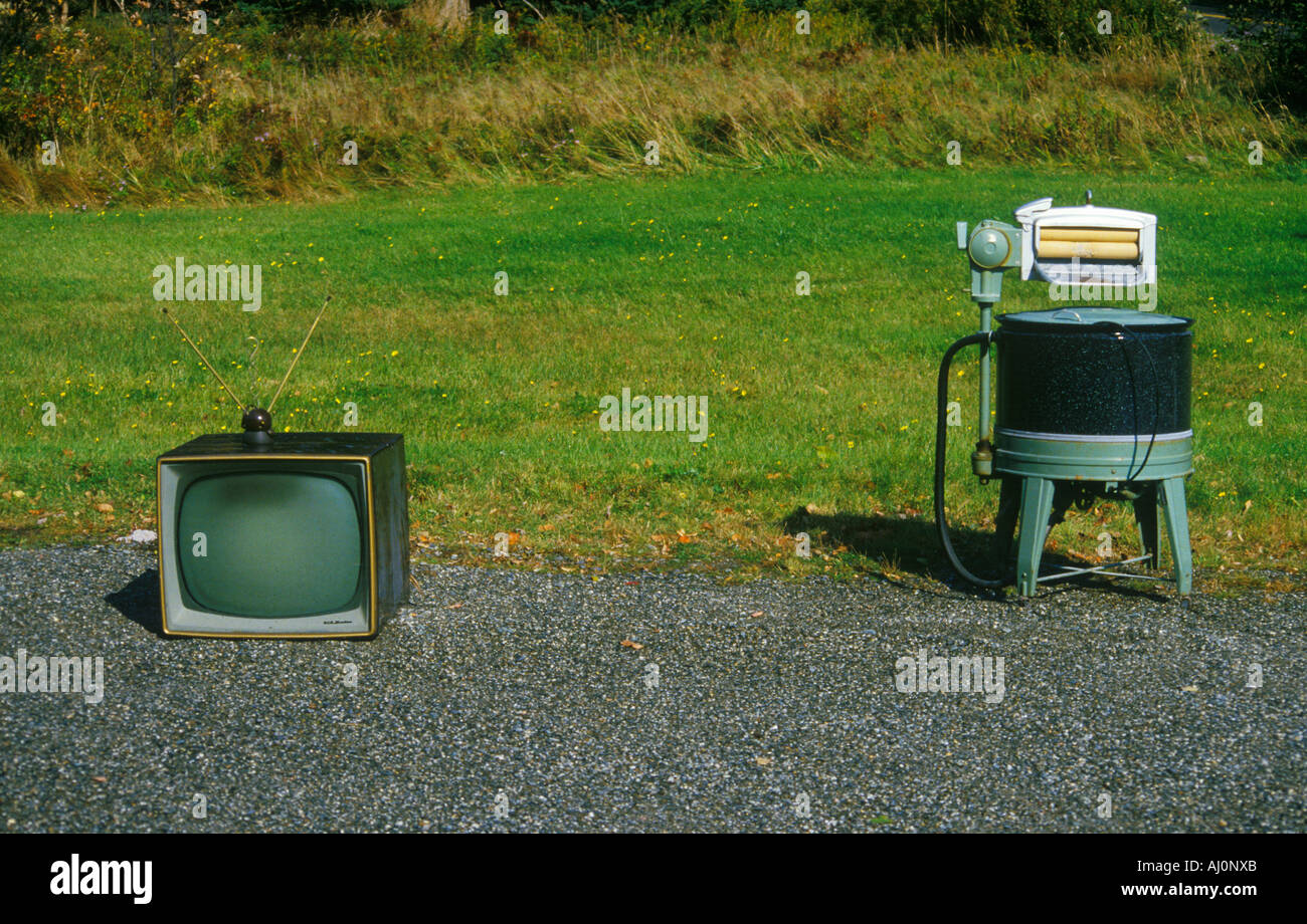 Old retro television set with rabbit ears antennae with old fashioned washing machine New England Stock Photo