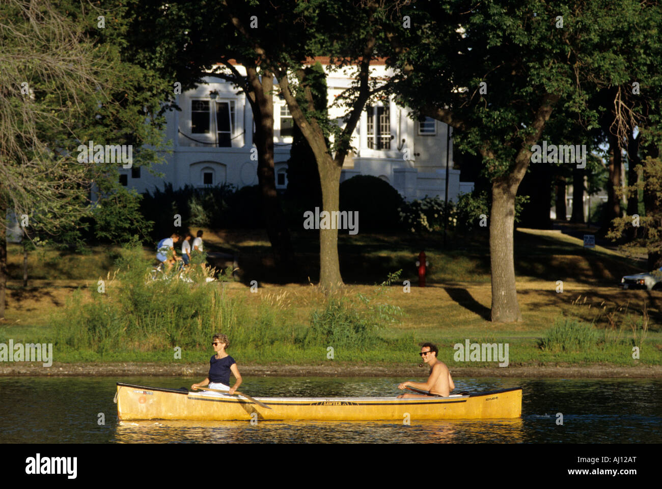 COUPLE CANOES ON LAKE OF THE ISLES IN THE HEART OF MINNEAPOLIS, MINNESOTA.  SUMMER. Stock Photo