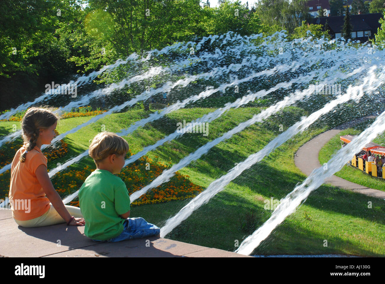 Kinder bestaunen die Kleinbahn Tatzelwurm vor Wasserspielen im Höhenpark Killesberg Stuttgart Stock Photo