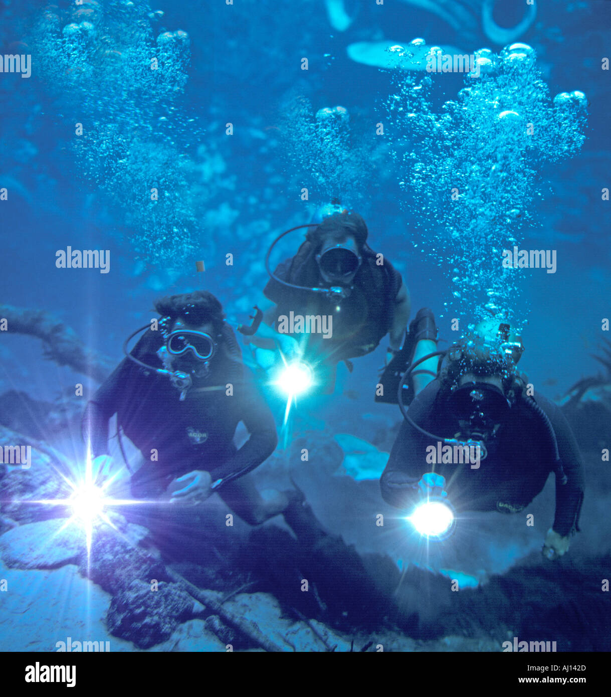 three skin divers exploring underwater cave in Florida USA Stock Photo