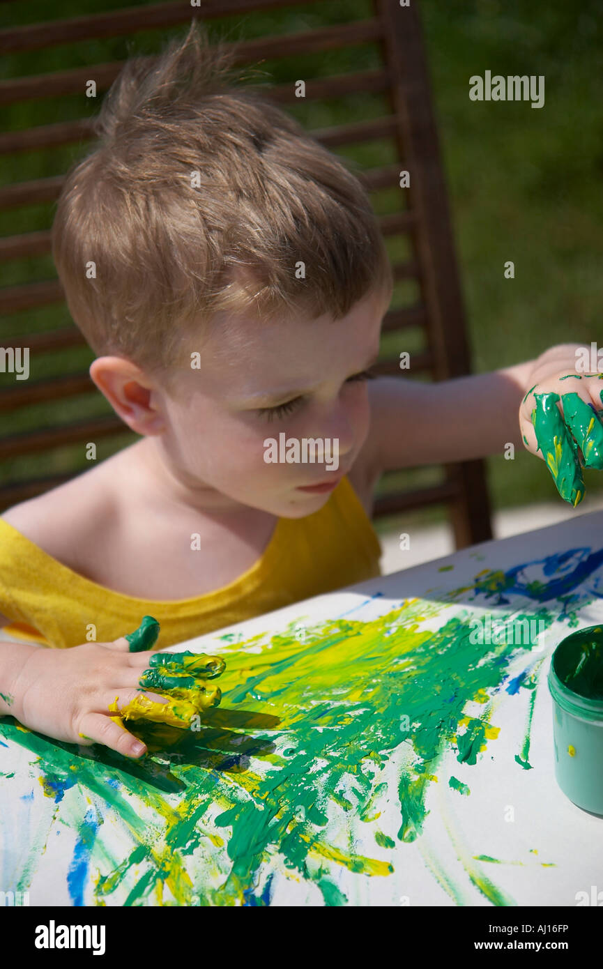 little boy painting with finger colours Stock Photo Alamy