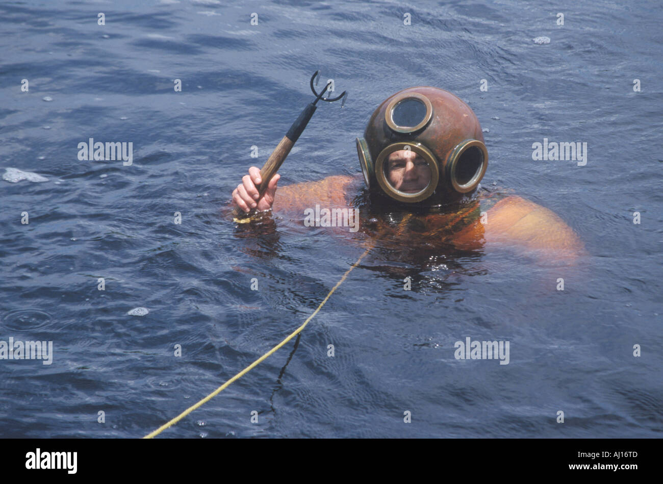 Historic Greek sponge diver in antique diving suit dives for sponges in