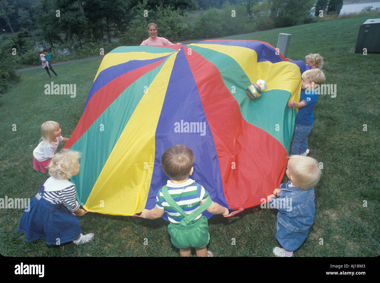 Daycare children playing a parachute game Stock Photo Alamy
