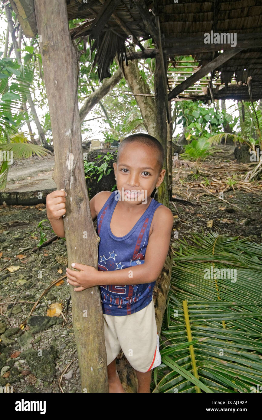 Young boy stands by traditional pit oven or uhm for cooking dinner Kosrae Federated States of Micronesia FSM Stock Photo