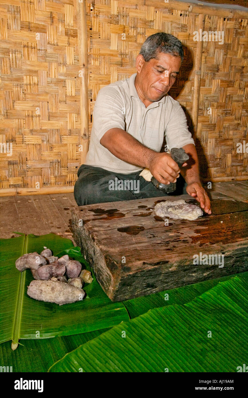 Kosrae man pounds cooked taro root first step in making Kosrae dessert called fa fa Stock Photo