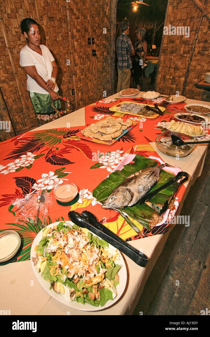 Kosrae woman stands by table holding typical Kosrae pot luck dinner Stock Photo