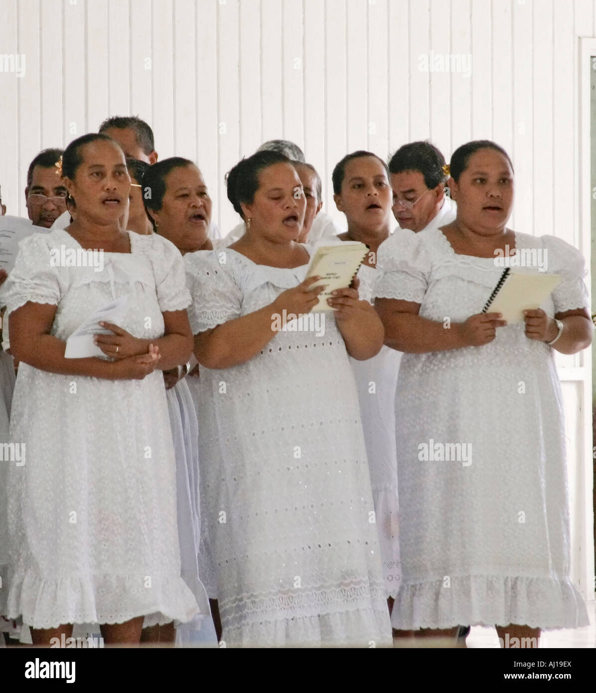 Micronesian women dressed in white lace and village men sing four part choral harmony during church service in Lelu in Kosrae Stock Photo