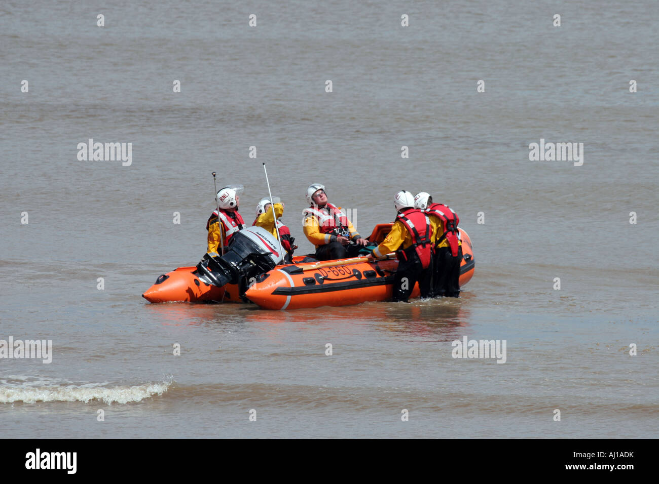 RNLI dinghy and crew watching flare Stock Photo