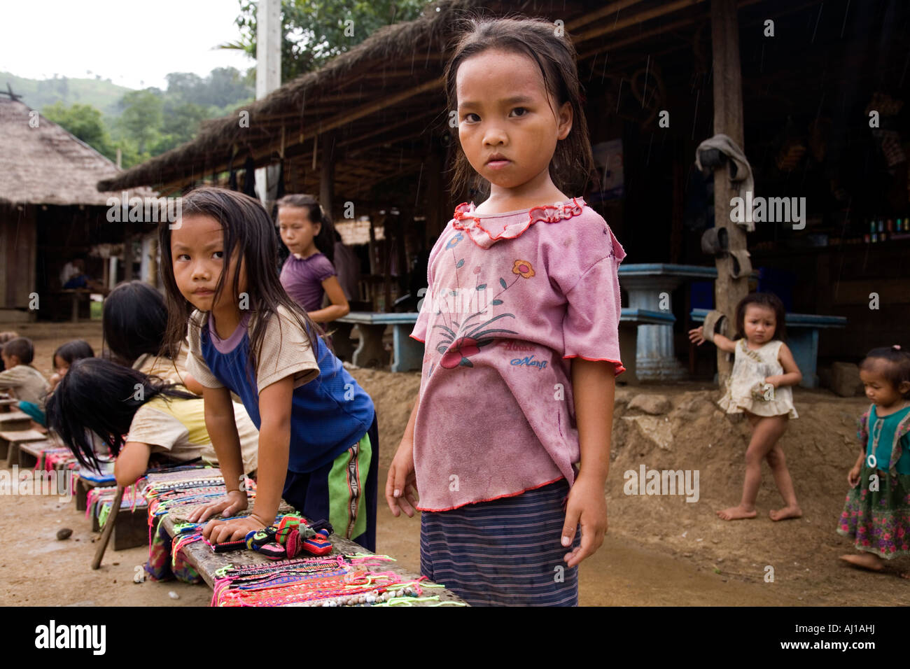 Line of children selling wrist bands to tourists in Hmong tribal village near Luang Prabang Laos Stock Photo
