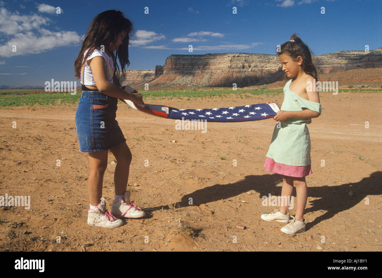 Two girls folding the American flag Lee Ranch southern UT Stock Photo ...