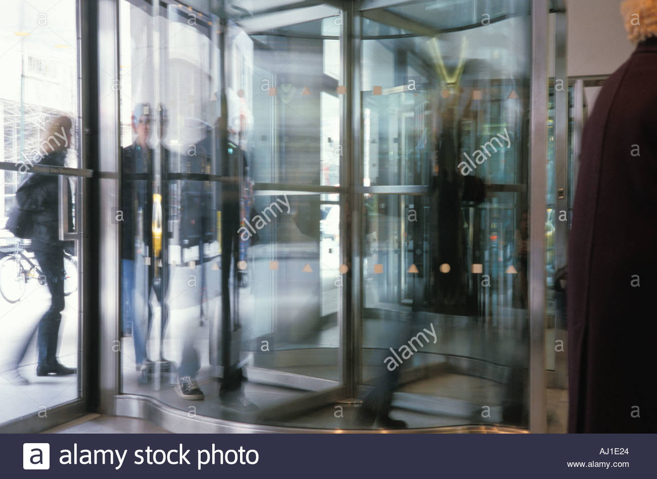 People Walking Through A Revolving Door Stock Photo 1187363
