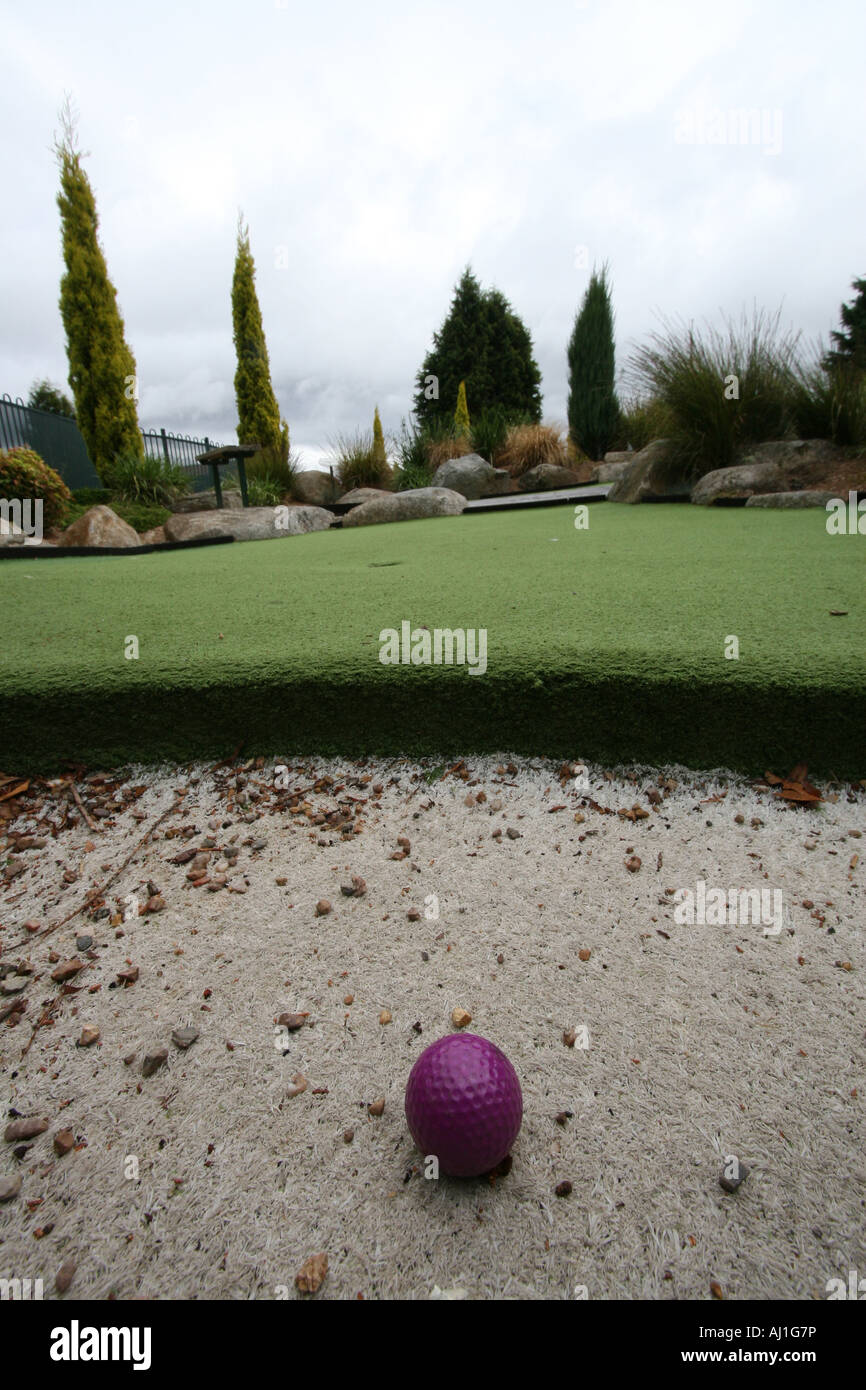 putt putt put put golf ball in a sand bank Stock Photo