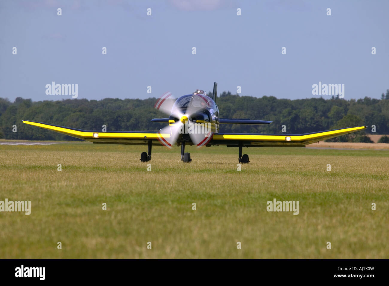 Light aircraft taking off on grass motion blur on the propeller Stock Photo