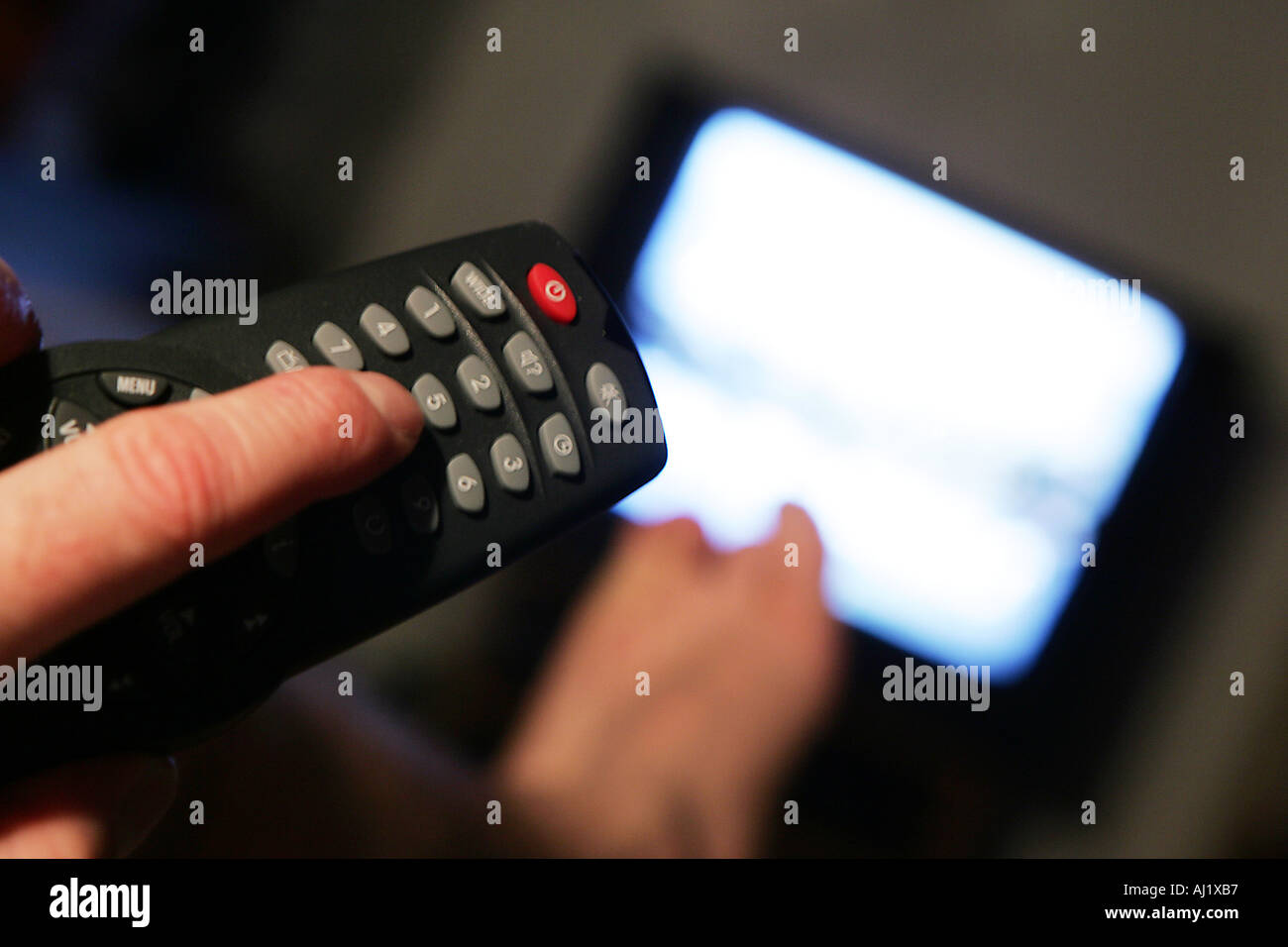 Man in front of an TV Remote control Stock Photo